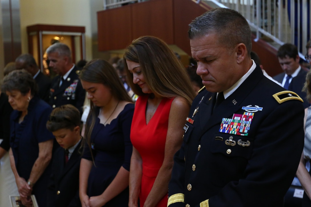 Brig. Gen. Michael Warmack, Chief of Army Reserve Command Operations, Plans and Training, and his family pray during the benediction portion of Warmack’s retirement ceremony at Fort Bragg, N.C., June 29, 2017. Warmack praised his mother, Toni, and his wife, Laura, in his continued success. (U.S. Army Reserve photo by Staff Sgt. Felix R. Fimbres)