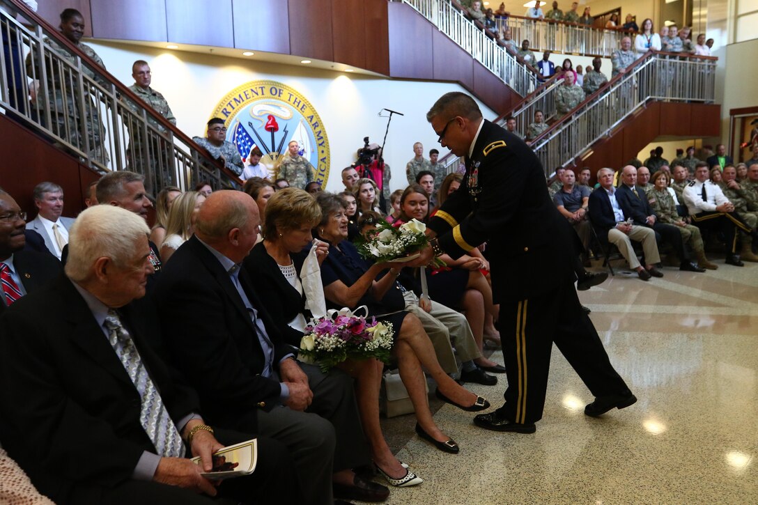Brig. Gen. Michael Warmack, Chief of Army Reserve Command Operations, Plans and Training, presents his mother, Toni, with a bouquet of flowers during his retirement ceremony at Fort Bragg, N.C., June 29, 2017. Warmack honored his wife and parents during the ceremony, especially his mother, Toni, who he credits as being an instrumental part of his life. (U.S. Army Reserve photo by Staff Sgt. Felix R. Fimbres)