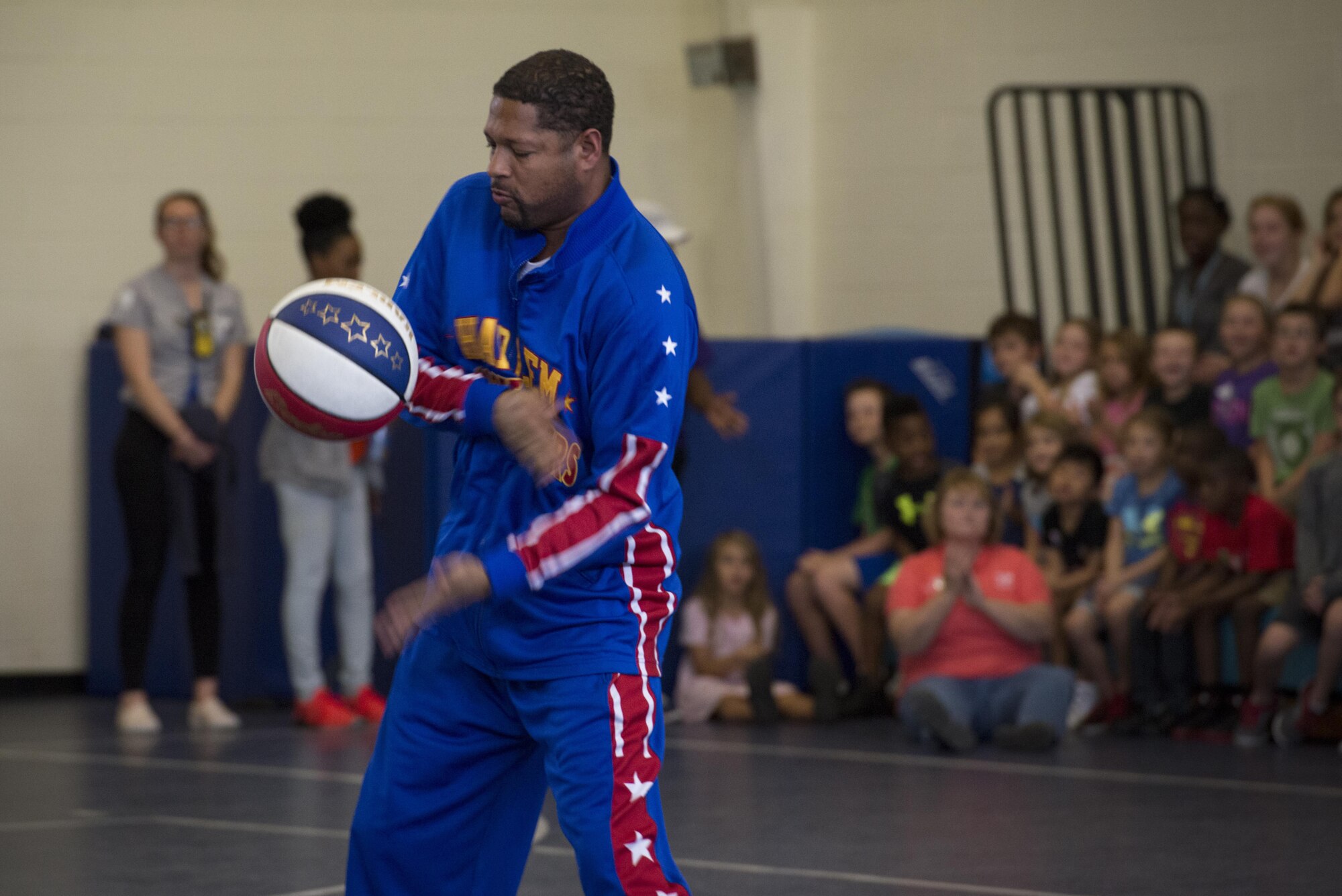 Harlem Globetrotter “Handles” performs a trick during a show, June 30, 2017, at Moody Air Force Base, Ga. During their visit, the globetrotters performed tricks, interacted with children, and instilled life lessons such as anti-bullying and the importance of school. (U.S. Air Force photo by Airman 1st Class Lauren M. Sprunk)