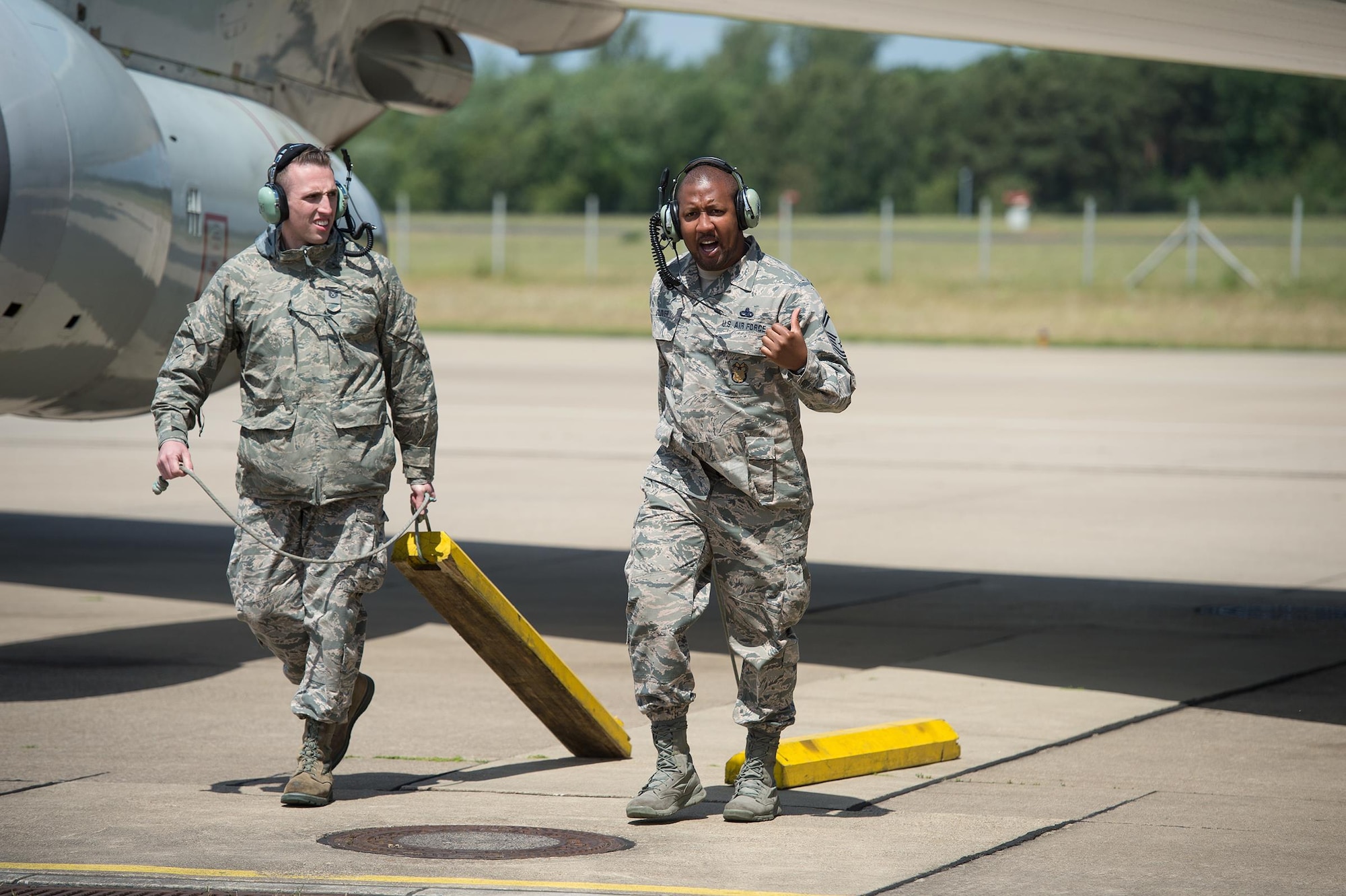 Tech. Sgt. Jordan Wright and Senior Master Sgt. Alphonzo Glover, both maintenance Reservists from the 513th Air Control Group, pull chocks from an E-3 Sentry Airborne Warning and Control System aircraft on June 7, 2017, at NATO Air Base Geilenkirchen, Germany, prior to a mission in support of BALTOPS 2017. Both Airmen are a part of the nearly 100 Reservists supporting the BALTOPS 2017 exercise, which involves 50 ships and submarines and 40 aircraft from 14 member nations. (U.S. Air Force photo/2nd Lt. Caleb Wanzer)