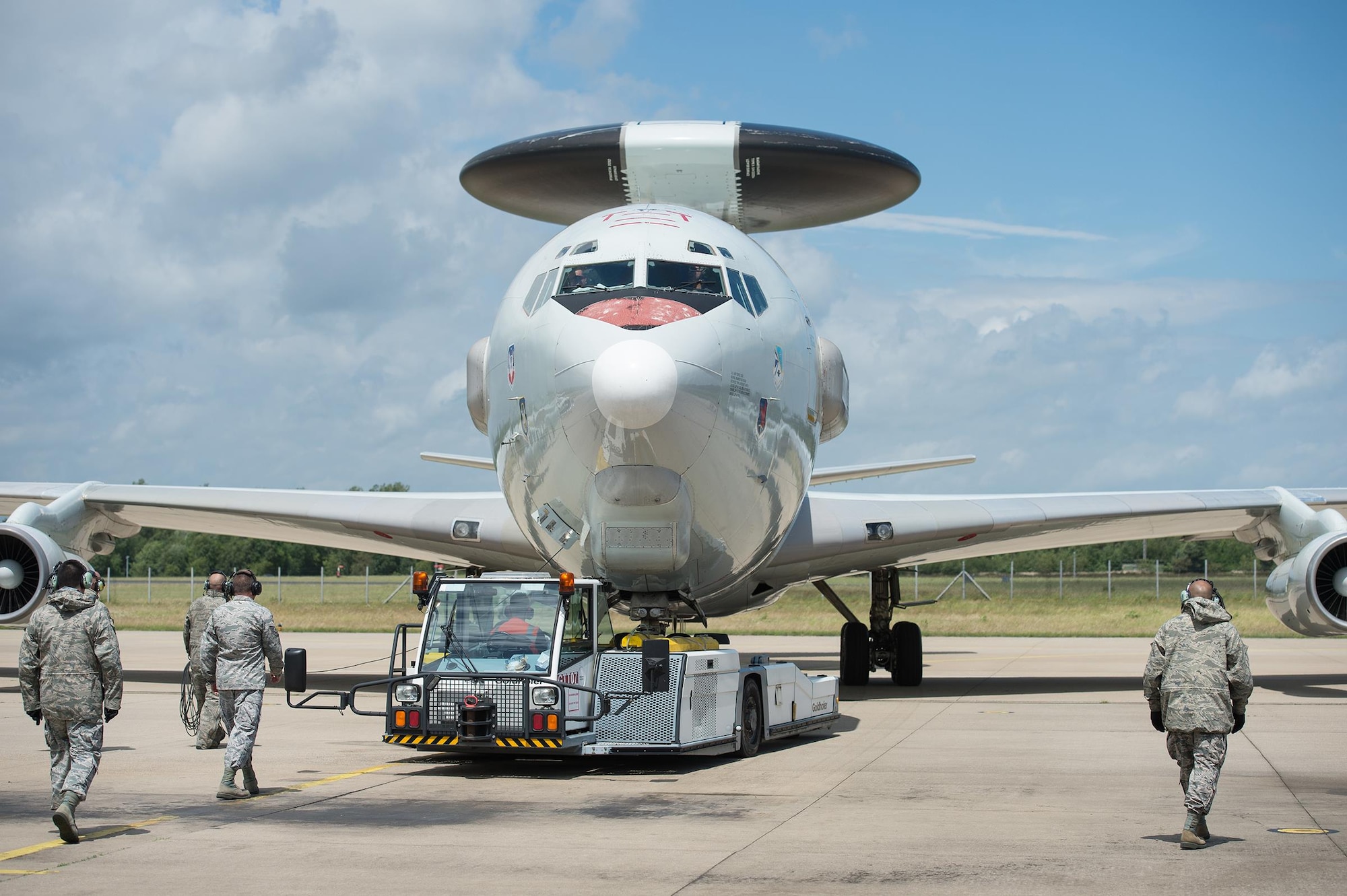 An aircraft tow vehicle backs out an E-3 Sentry Airborne Warning and Control System aircraft flown by reservists from the 513th Air Control Group on June 7, 2017, at NATO Air Base Geilenkirchen, Germany. Nearly 100 reservists from the 513th are deployed in support of the BALTOPS 2017 exercise, which involves 50 ships and submarines and 40 aircraft from 14 member nations. (U.S. Air Force photo/2nd Lt. Caleb Wanzer)