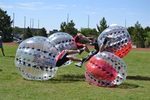 Knockerball players send each other flying during the Summer Slam Base Picnic at Schriever Air Force Base, Colorado, July 15, 2016. Inflatable bounce houses, face painting and other activities will be at this year’s picnic as well. (U.S. Air Force photo/Brian Hagberg)
