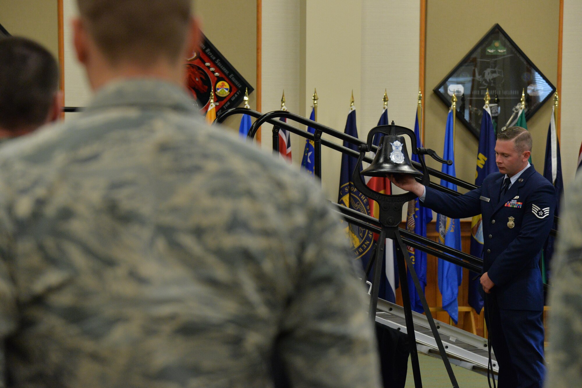 Staff Sgt. Glenn Holden, 341st Security Forces Squadron military working dog handler, rings a bell during a remembrance ceremony at the Grizzly Bend June 30, 2017, for MWD Aslan who passed away in early June. The bell was rang three times to signify bringing a dog home. (U.S. Air Force photo/Airman 1st Class Daniel Brosam)