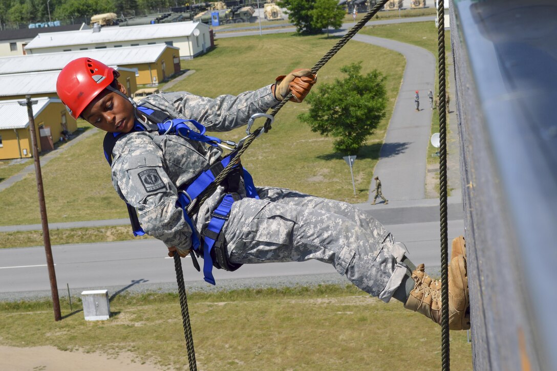 A junior ROTC cadet looks below her before rappelling down a 54-foot wall during the Cadet Leadership Challenge in Grafenwoehr, Germany, June 22, 2017. Nearly 130 cadets from Department of Defense Education Activity Europe high schools attended the weeklong event. Army photo by Sarah Tate