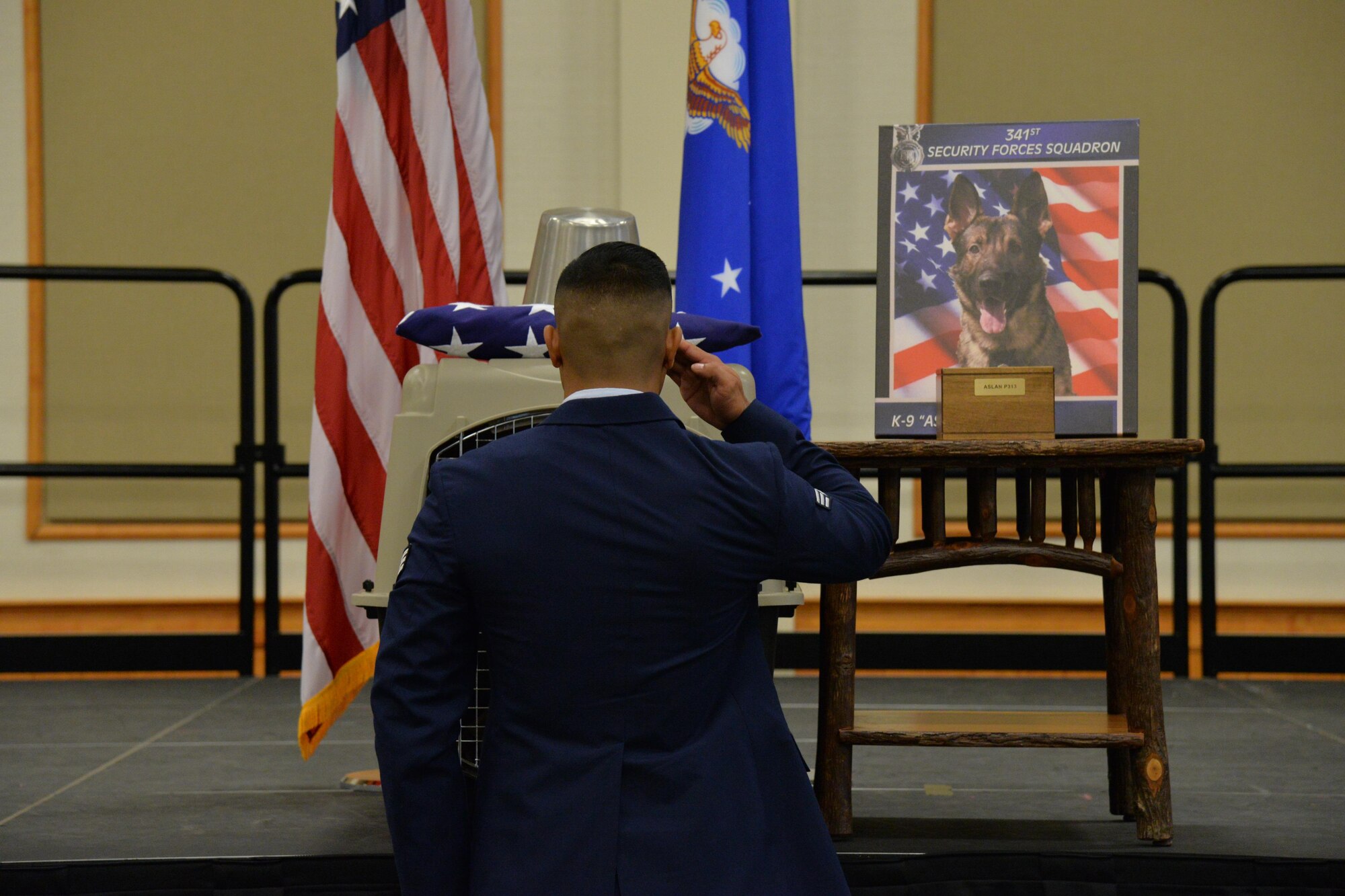 Senior Airman Keith Retuyan, 341st SFS military working dog handler, pays his final respects to MWD Aslan during a remembrance ceremony at the Grizzly Bend June 30, 2017, at Malmstrom Air Force Base, Mont. Retuyan was Aslan’s handler at the time of his passing. (U.S. Air Force photo/Airman 1st Class Daniel Brosam)