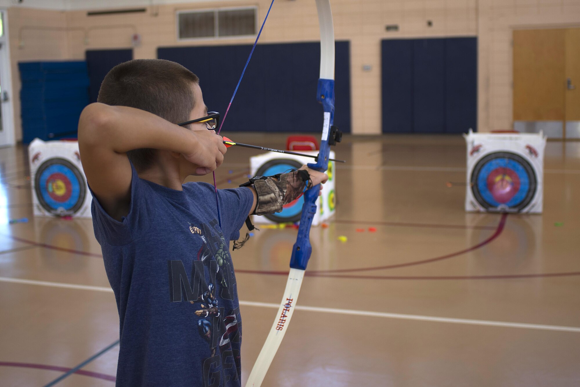 Elod Pecsvarady, a youth center member, prepares to shoot an arrow at a balloon target at MacDill Air Force Base, Fla., June 23, 2017. During the archery camp, the students learned how to properly hold, aim and shoot arrows. (U.S. Air Force photo by Airman 1st Class Caleb Nunez)