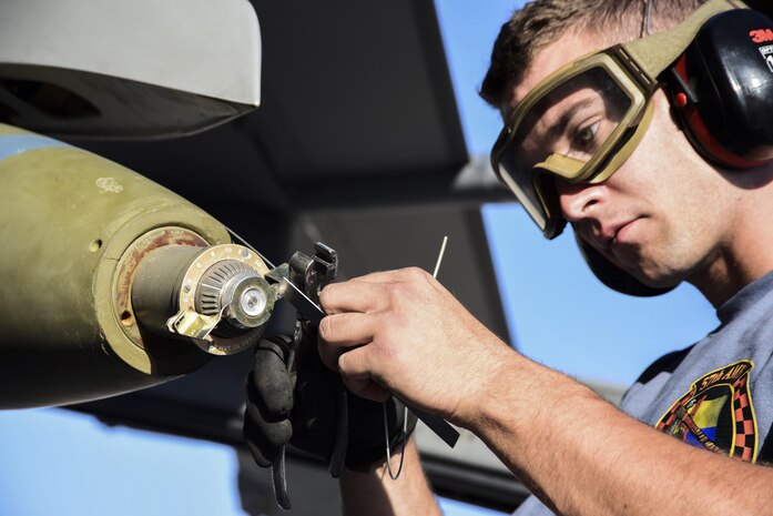 An Airman from the 57th Maintenance Group secures a bomb to an F-16 Fighting Falcon, assigned to the 16th Weapons Squadron, during a load crew competition June 30, 2017, at Nellis Air Force Base, Nev. Each team was tested on their timeliness and accuracy while loading and unloading munitions on their aircraft. (U.S. Air Force photo by Airman 1st Class Andrew D. Sarver/Released)