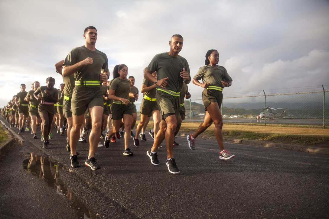 Marines and Sailors with Headquarters Battalion conduct a 2-mile motivational run aboard Marine Corps Base Hawaii on June 30, 2017. The battalion conducted the motivational run to build unit cohesion and boost morale amongst the battalion. (U.S. Marine Corps photo by Lance Cpl. Matthew Kirk)