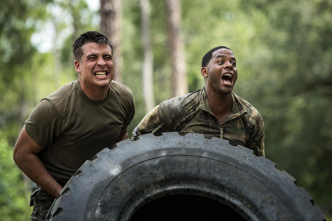 Airmen flip a tire during the Scorpion Fire Team Challenge at Moody Air Force Base, Ga., June 29, 2017. The airmen are assigned to the 822nd Base Defense Squadron. The challenge includes written tests and physical and skills competitions. Air Force photo by Senior Airman Janiqua P. Robinson