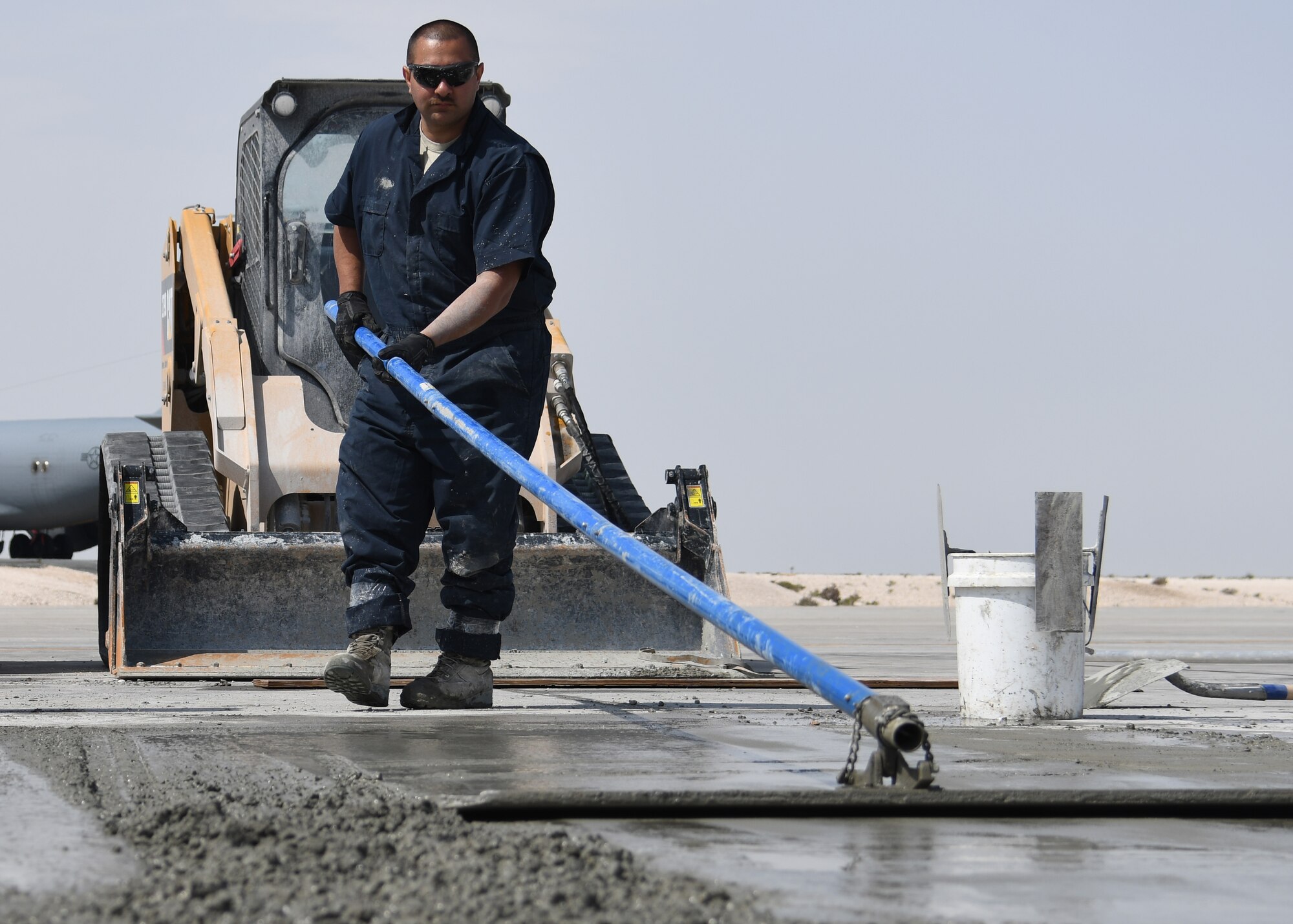 U.S. Air Force Staff Sgt. Michael Hidalgo, a heavy equipment and constructions journeyman with the 379th Expeditionary Civil Engineer Squadron Pavements and Equipment Flight, smooths out wet concrete at Al Udeid Air Base, Qatar, Feb. 21, 2017. Using a bull float tool, Costa brought the concrete “sludge” to the top, allowing for the concrete to have a smooth finish. (U.S. Air Force photo by Senior Airman Miles Wilson)