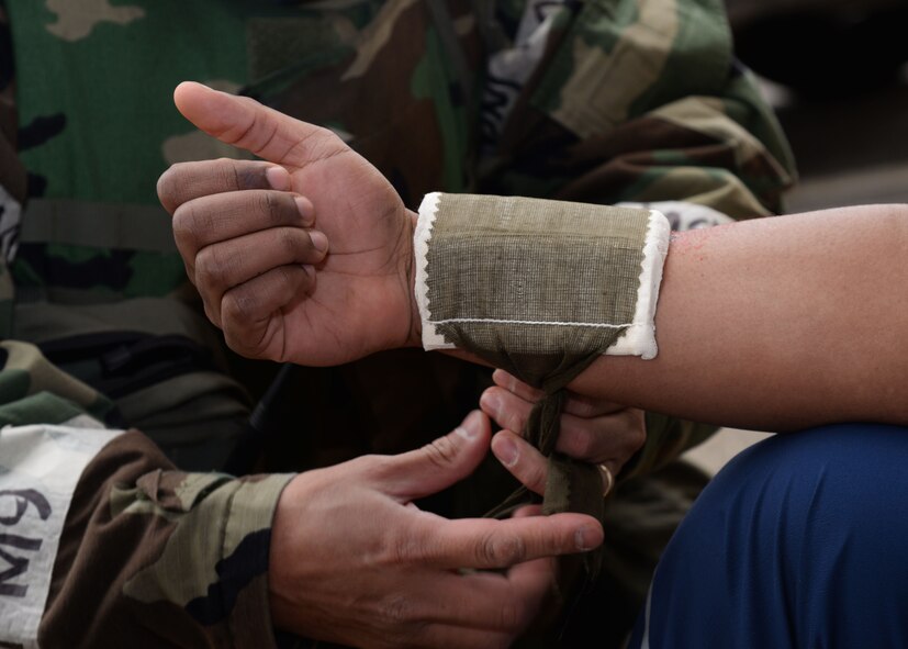U.S. Air Force Tech. Sgt. Arthur Barnachea, 51st Civil Engineer Squadron heating, ventilation, and air conditioning craftsman, dresses the arm fracture of Airman First Class Bryce Carter, 51st Civil Engineer Squadron heating, ventilation, and air conditioning specialist, during Exercise Beverly Herd 17-1 at Osan Air Base, Republic of Korea, March 1, 2017. The exercise was held to assess how well various units worked cohesively to respond to incidents and treat injured personnel. (U.S. Air Force photo by Tech. Sgt. Ashley Tyler)