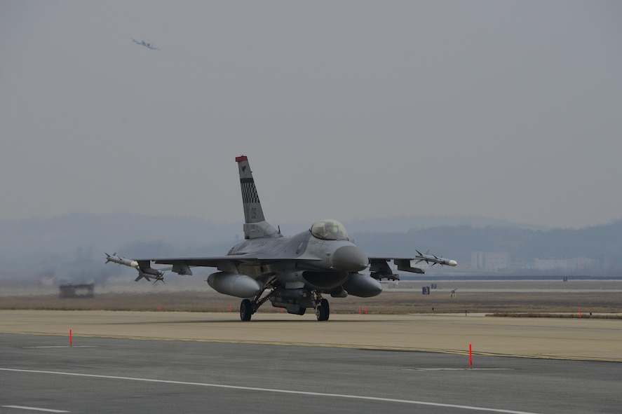 An F-16 Fighting Falcon assigned to the 36th Fighter Squadron taxis to the runway for a training mission while an A-10 Thunderbolt II from the 25th Fighter Squadron takes off during Exercise Beverly Herd 17-1 at Osan Air Base, Republic of Korea, March 1, 2017. Pilots from both fighter squadrons flew multiple sorties during exercise Beverly Herd, honing their flying skills and ability to work around the rugged ROK landscape. (U.S. Air Force photo by Staff Sgt. Victor J. Caputo)