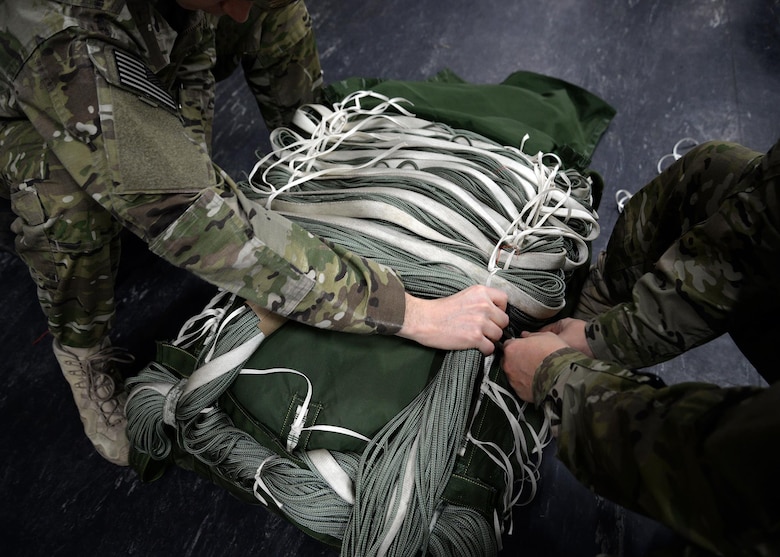 U.S. Air Force Air Commandos from the 352d Special Operations Support Squadron Aerial Delivery secure a parachute Feb. 15, 2017, on RAF Mildenhall, England. The aerial delivery flight is made up of three Air Force specialties: loadmasters, aircrew flight equipment, and air transportation. (U.S. Air Force photo by Senior Airman Christine Halan) 