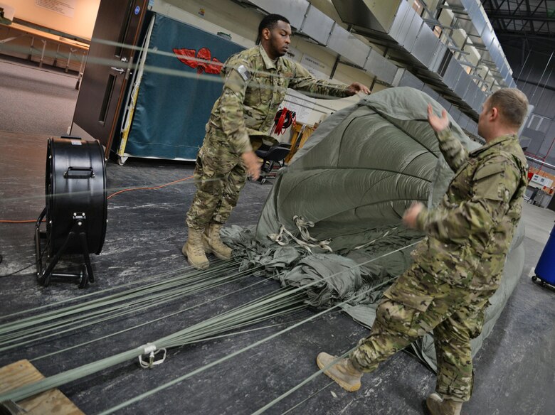 U.S. Air Force Staff Sgt. Jarryd Dooley, left, and U.S. Air Force Staff Sgt. Brian Demik, both 352d Special Operations Support Squadron Aerial Delivery riggers, untangle a parachute Feb. 15, 2017, on RAF Mildenhall, England. The aerial delivery flight uses industrial vehicles to collect the cargo after it’s been dropped from the aircraft. (U.S. Air Force photo by Senior Airman Christine Halan)