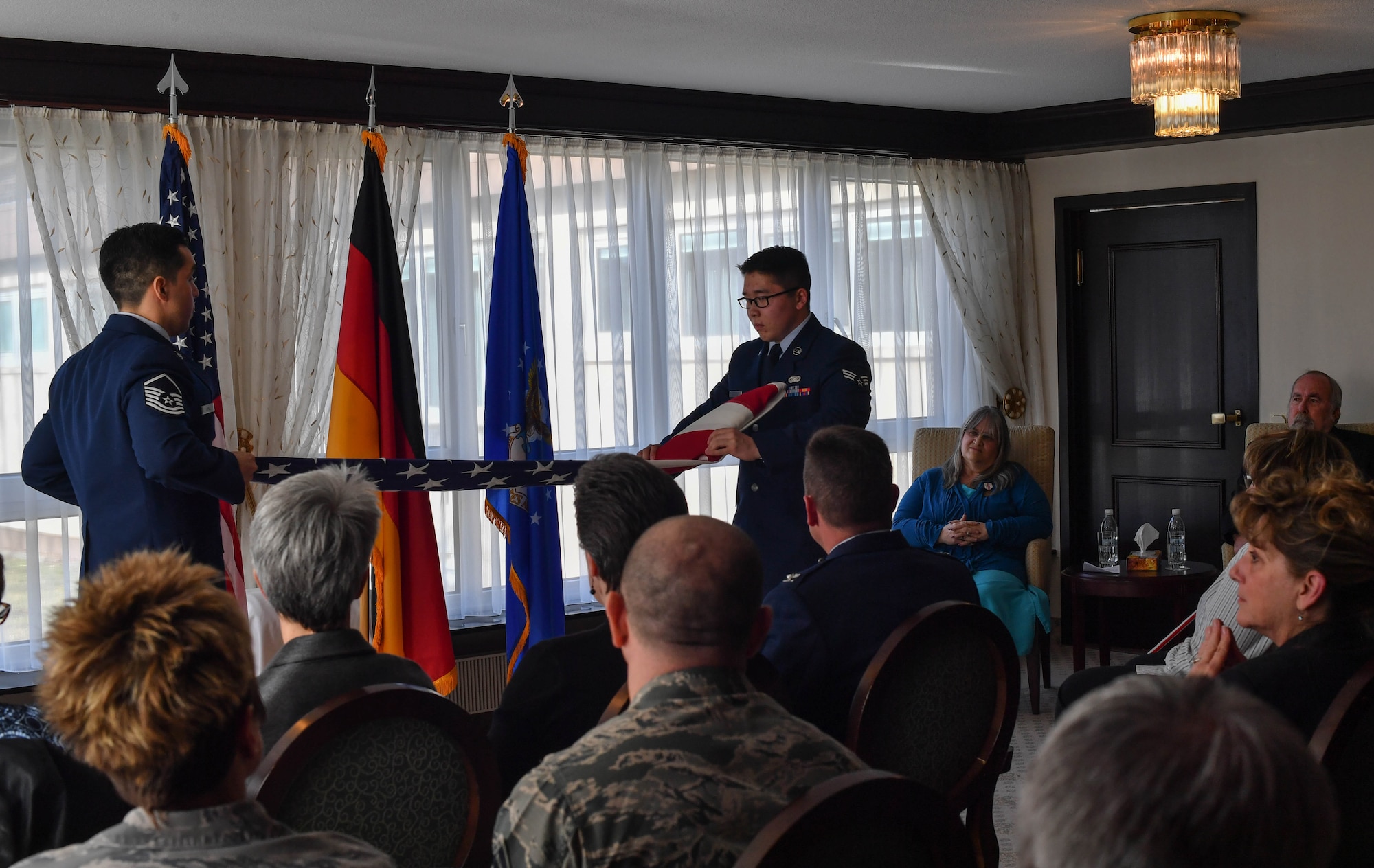 Master Sgt. Henry Lopez, U.S. Air Forces in Europe readiness and plans manager, and Senior Airman Zachary Abraham, 435th Security Forces Squadron commander’s support staff, fold an American flag during a dual retirement ceremony on Ramstein Air Base, Germany, Feb. 24, 2017. John and Colynn Hamilton, USAFE management analyst and human resources specialist respectively, as well as husband and wife, retired after more than 80 years of combined service. (U.S Air Force photo by Senior Airman Tryphena Mayhugh)