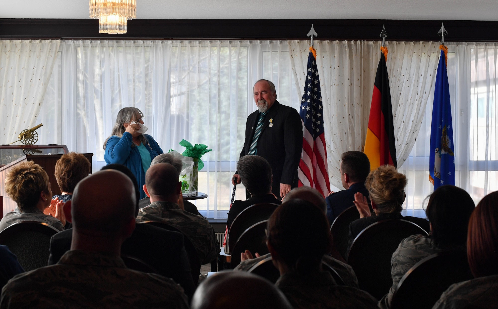 Colynn and John Hamilton, U.S. Air Forces in Europe human resources specialist and management analyst respectively, speak during their dual retirement ceremony on Ramstein Air Base, Germany, Feb. 24, 2017. After over 80 years of combined service, the Hamiltons retired to spend time with their five kids and 12 grandchildren. (U.S Air Force photo by Senior Airman Tryphena Mayhugh)