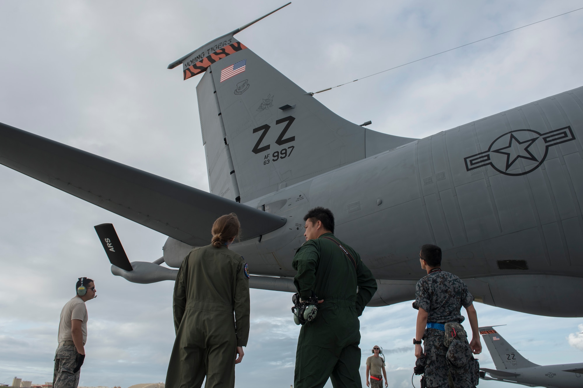 U.S. Air Force Airman 1st Class Luke Story, 909th Air Refueling Squadron boom operator, prepares to conduct aerial refueling while being observed by Japan Air Self-Defense Force 1st Lt. Yoshifumu Takase March 1, 2017, off the coast of Guam. The refueling was conducted for exercise Cope North, an annual gathering of Japanese, U.S. and Australian service members who train to increase combat readiness and interoperability. (U.S. Air Force photo by Senior Airman John Linzmeier)