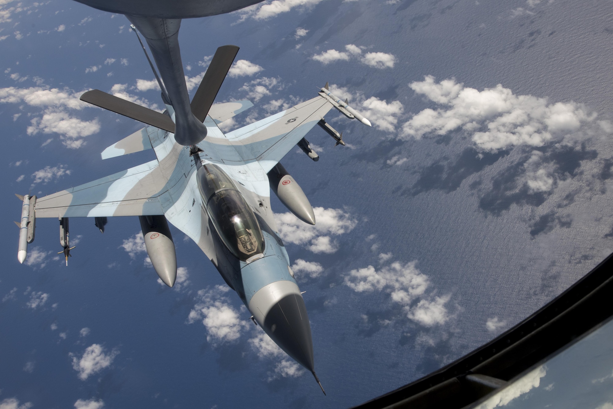 U.S. Air Force Airman 1st Class Luke Story, 909th Air Refueling Squadron boom operator, prepares to conduct aerial refueling while being observed by Japan Air Self-Defense Force 1st Lt. Yoshifumu Takase March 1, 2017, off the coast of Guam. The refueling was conducted for exercise Cope North, an annual gathering of Japanese, U.S. and Australian service members who train to increase combat readiness and interoperability. (U.S. Air Force photo by Senior Airman John Linzmeier)