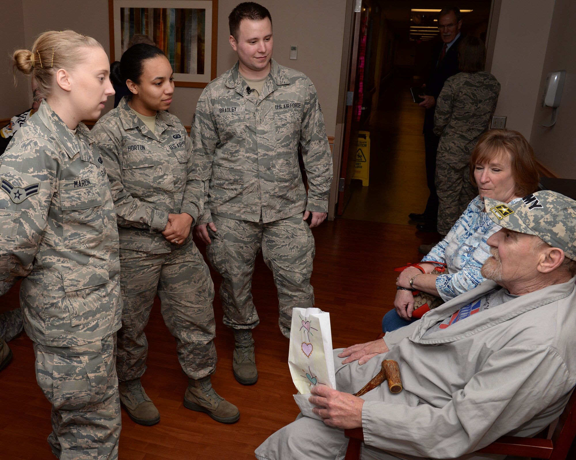 Airman 1st Class Lillian March (left), 88th Comptroller Squadron travel technician, Airman 1st Class Brittany Horton (middle), 88th Comptroller Squadron customer service technician, and Airman 1st Class Nicholas Bradley (right), 88th Comptroller Squadron financial services supervisor speaks with Dennis Hodson, Army veteran and patient at the VA Medical Center, Feb. 14.  The VA medical center hosted the Valentine’s for Vets event to honor veterans and increase community awareness of the VA’s role in providing comprehensive medical care to the nation’s Veterans. (U.S. Air Force photo/Michelle Gigante)