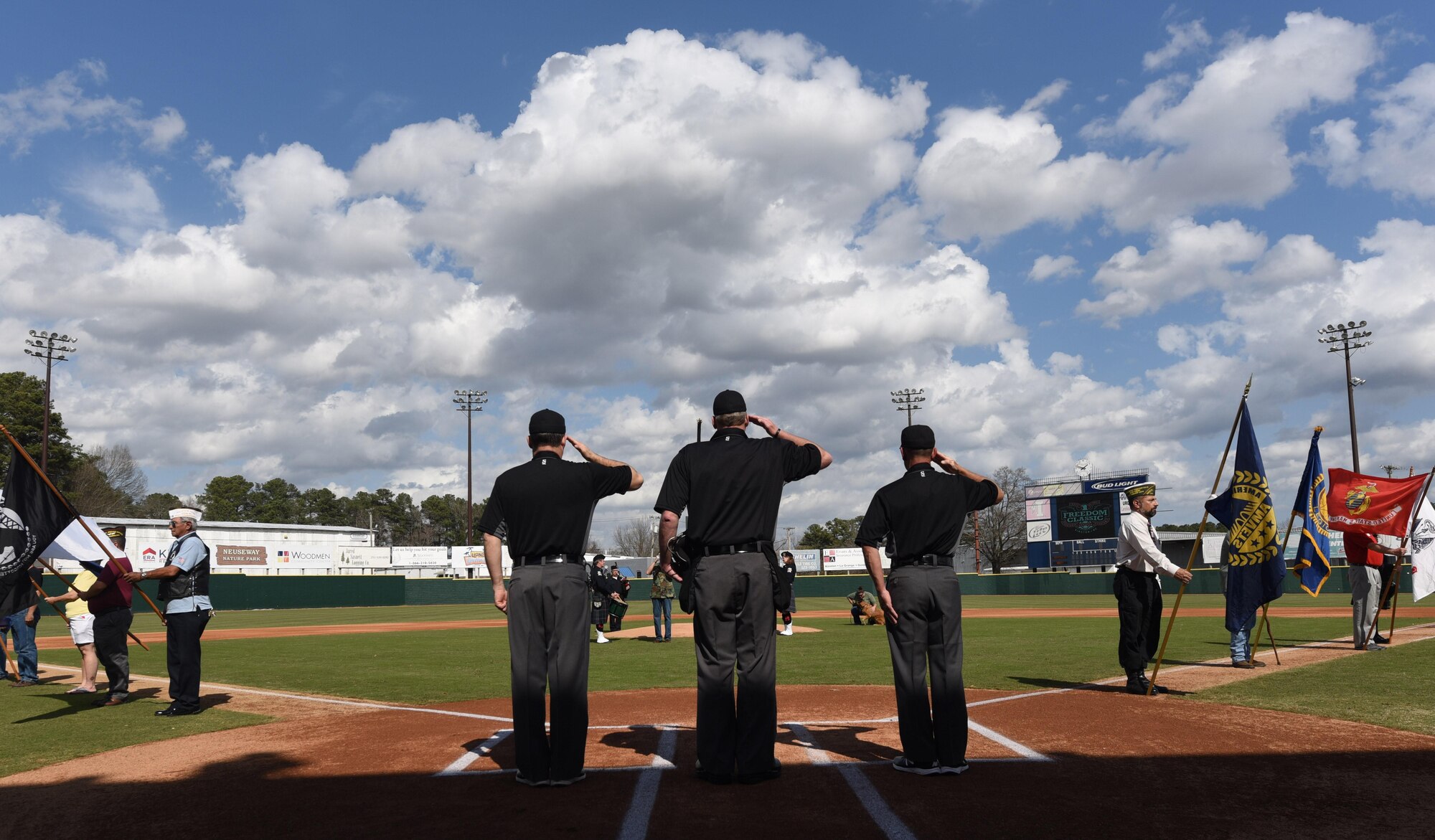 Umpires render salutes during the National Anthem at the Freedom Classic baseball series, Feb. 25, 2017, at Grainger Stadium in Kinston, North Carolina. The U.S. Air Force Academy beat the U.S. Naval Academy 2-1 in the series. (U.S. Air Force photo by Airman Miranda A. Loera) 