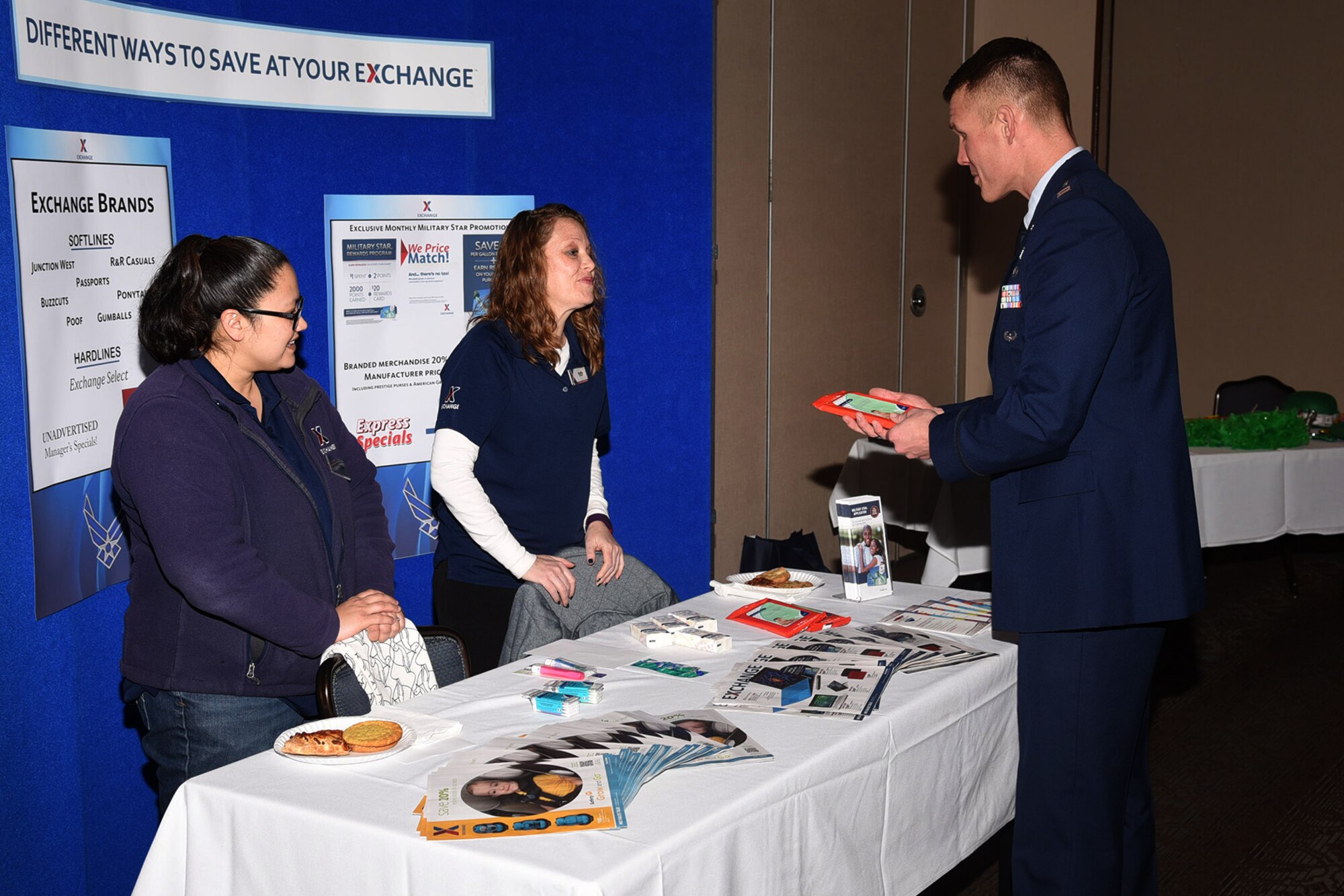 PETERSON AIR FORCE BASE, Colo. – Captain Joshua Flynn, 21st Space Wing chaplain, gathers Base Exchange information from Kristie Thomas and Kathy Dugan, Base Exchange employees, during the Financial Fair at The Club, Peterson Air Force Base, Colo  Feb. 28, 2017. The Exchange offers savings on commercial and grocery items. (U.S. Air Force photo by Robb Lingley)  