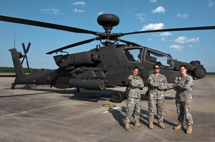 1st Lt. Jenna Pitcher and Staff Sgt. Lauren Rhodes assist U.S. Army Chief Warrant Officer Deborah Glenn, Company B, 1-151st Attack and Reconnaissance Battalion, South Carolina Army National Guard, on a AH-64D Apache helicopter at McEntire Joint National Guard Base in Eastover, South Carolina, August 4, 2015.