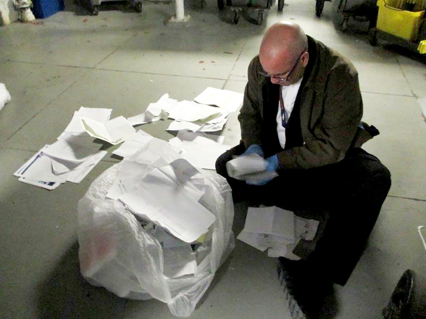A Joint OPSEC Support Element agent weeds through documents that have been thrown away.