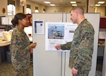 Marine Corps Chief Warrant Officer 3 Jacqueline Elazier-Allison, operations officer in-charge, and Marine Corps Maj. Christopher Story, executive officer of the DLA Aviation Marine Corps Customer Facing Division, discuss aviation weapon system statistics at Defense Supply Center Richmond, Virginia.