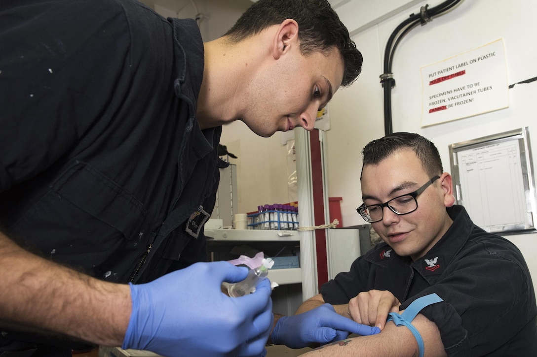 Navy Seaman Evan Stewart, left, receives intravenous training from Navy Petty Officer 2nd Class Riley Garn aboard the aircraft carrier USS Carl Vinson in the South China Sea, Feb. 21, 2017. Stewart is an airman, and Garn is a hospital corpsman. Navy photo by Petty Officer 3rd Class Matt Brown 