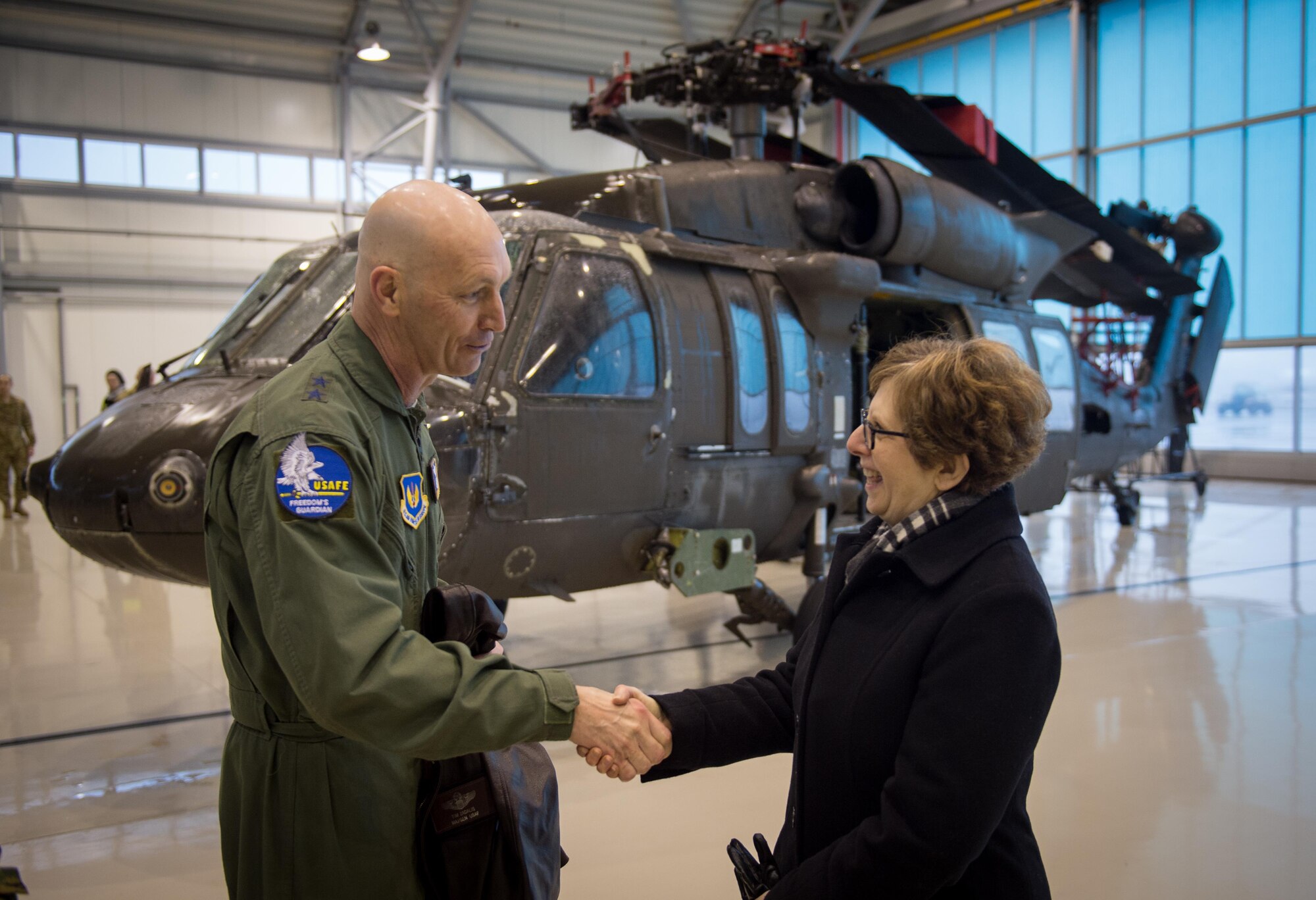 Maj. Gen. Timothy Zadalis thanks U.S. Ambassador to Latvia, Nancy Bikoff Pettit, for welcoming the U.S. military to Latvia during an event at Riga International Airport, Mar. 1, 2017. A U.S. Air Force C-5M Super Galaxy delivered UH-60 Black Hawks for the U.S. Army in Latvia. Five Black Hawk helicopters will be deployed to Latvia as part of a larger contingent of helicopters and personnel deployed to support Operation Atlantic Resolve, a U.S. commitment to maintaining peace and stability in the European region. (U.S. Air Force photo/Tech. Sgt. Ryan Crane)
