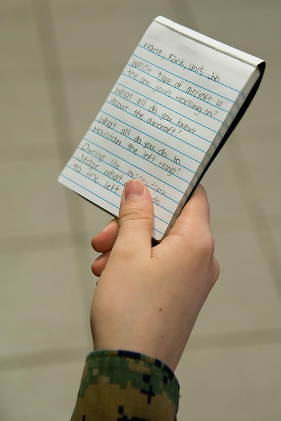 Marine Pfc. Scarlet Sharp, a Video Production and Documentation (VPD) student from the Defense Information School, Fort Meade, Md., holds her list of questions during an interview Feb. 23, 2017, on Dover Air Force Base, Del. Sharp and three other VDP students interviewed 436th Maintenance Squadron Isochronal (ISO) Maintenance Dock personnel as part of their final project that documented a C-5M Super Galaxy going through the ISO process. (U.S. Air Force photo by Roland Balik)