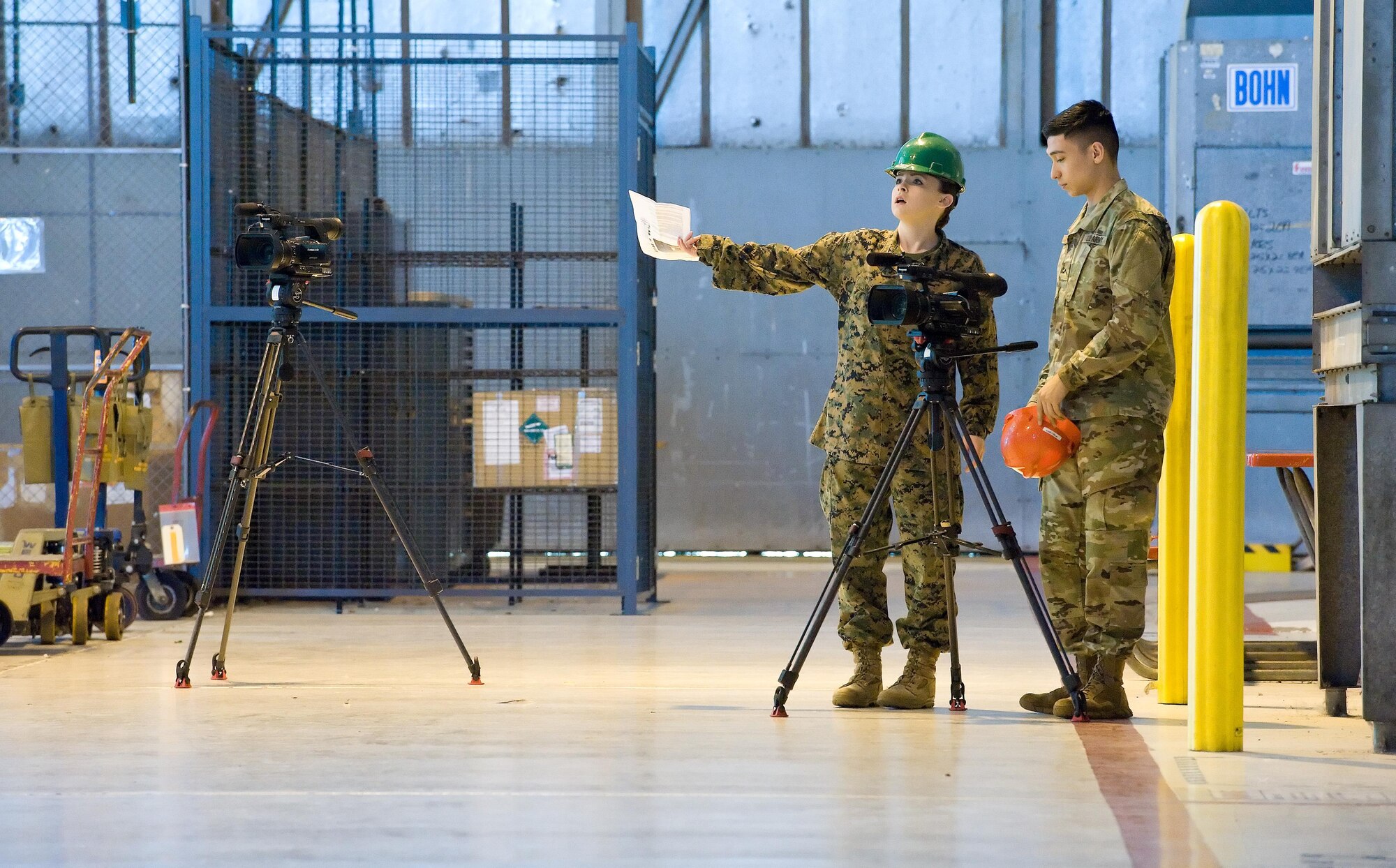 Marine Pfc. Scarlet Sharp and Army Pvt. Jay Diaz, both Video Production and Documentation (VPD) students from the Defense Information School, Fort Meade, Md., discuss camera angles of a C-5M Super Galaxy in the 436th Maintenance Squadron Isochronal (ISO) Maintenance Dock, Feb. 23, 2017, on Dover Air Force Base, Del. Sharp, Diaz and 14 other VDP students came to Dover to create a video product that will account for 60 percent of their final grade. (U.S. Air Force photo by Roland Balik)