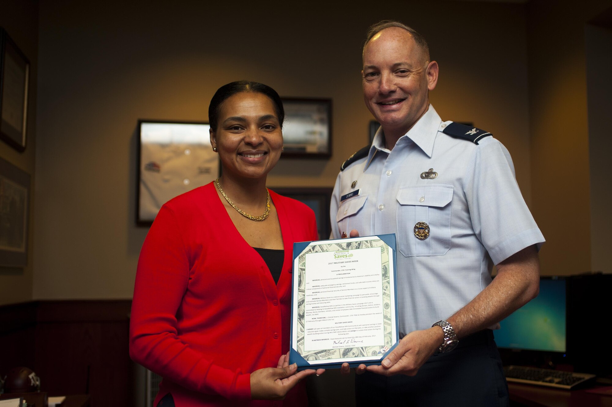 Qiana Woods, 17th Force Support Squadron Airman and Family Readiness Center work-life consultant, and Col. Michael Downs, 17th Training Wing Commander, present the Military Saves memorandum of understanding in the Norma Brown building on Goodfellow Air Force Base, Texas, February 28, 2017. Month of Military Saves is a campaign dedicated to encouraging military members to save money and set financial goals. (U.S. Air Force photo by Senior Airman Scott Jackson/Released)