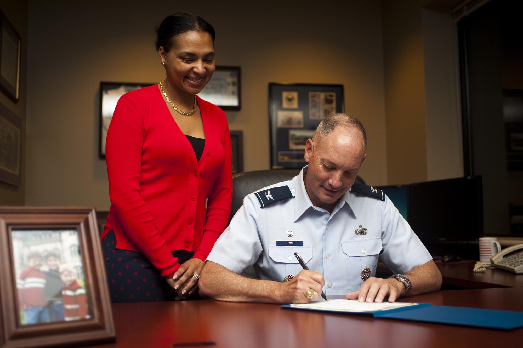 Qiana Woods, 17th Force Support Squadron Airman and Family Readiness Center work-life consultant, watches Col. Michael Downs, 17th Training Wing Commander, sign the Military Saves memorandum of understanding in the Norma Brown building on Goodfellow Air Force Base, Texas, February 28, 2017. Downs’ financial goal is to save towards retirement and a home. (U.S. Air Force photo by Senior Airman Scott Jackson/Released)