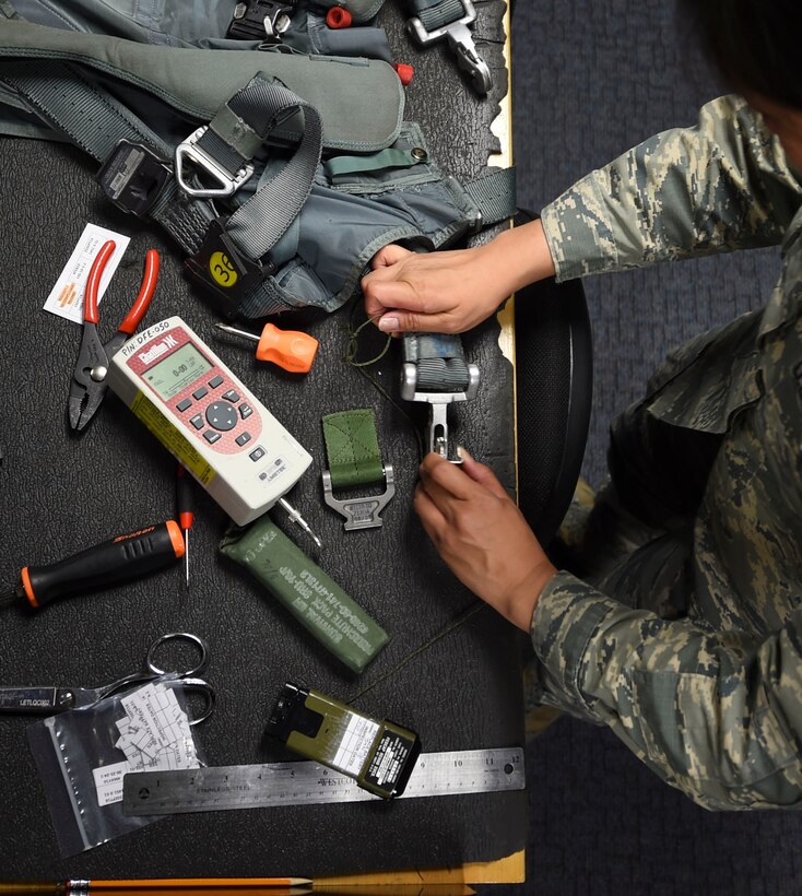 U.S. Air Force Airman 1st Class Femylyn Plan, 1st Operation Support Squadron aircrew flight equipment technician, repairs a parachute harness at Joint Base Langley-Eustis, Va., Feb. 27, 2017. The harness attaches to the parachute, securing a pilot to the chute in an emergency egress. (U.S. Air Force photo by Staff Sgt. Natasha Stannard)