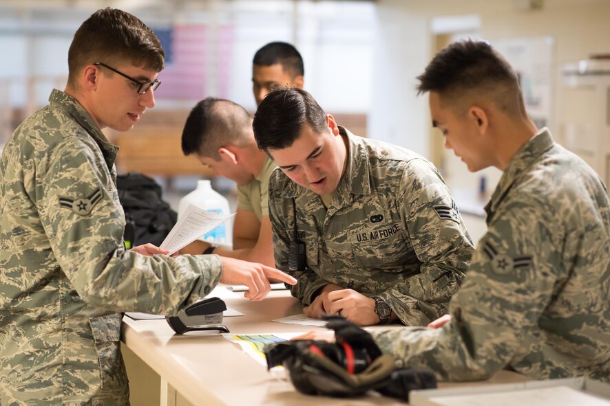 From left to right, Airman 1st Class Patric Vuletich, Senior Airman Alec Savaro and Airman 1st Class Roberto Robles check passenger weights while reviewing passenger manifests during this week's Battalion Mass Tactical Week exercise here. All three Airmen are passenger service agents in the 43d Air Mobility Squadron's Aerial Port Flight. Passenger service agents ensure accurate manifests and then escort paratroopers to C-17 and C-130 aircraft for airdrop missions. (U.S. Air Force photo/Marc Barnes)