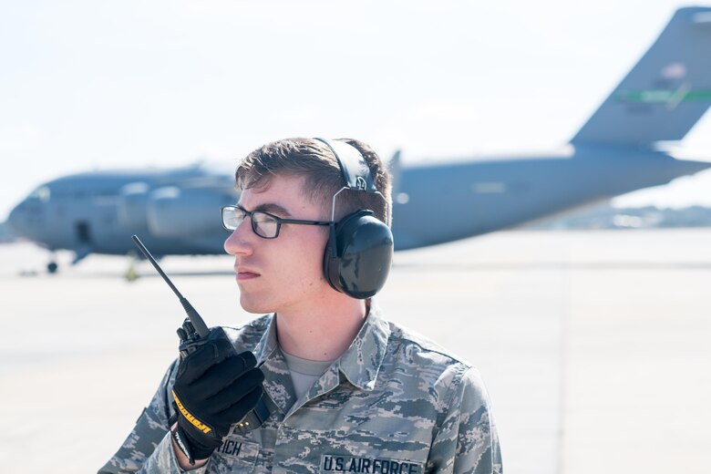 Airman 1st Class Patric Vuletich, a 43d Air Mobility Squadron Aerial Port passenger service agent, checks in with the Air Terminal Operations Center after escorting nearly 60 U.S. Army paratroopers to a C-130 Hercules from the 317th Airlift Wing at Dyess Air Force Base, Texas, on Green Ramp here Feb. 28. Vuletich and numerous other Airmen from the 43d Air Mobility Operations Group supported visiting Air Mobility Command aircrews and Soldiers from Fort Bragg during Battalion Mass Tactical Week, held here Feb. 27 through March 2. (U.S. Air Force photo/Marc Barnes)