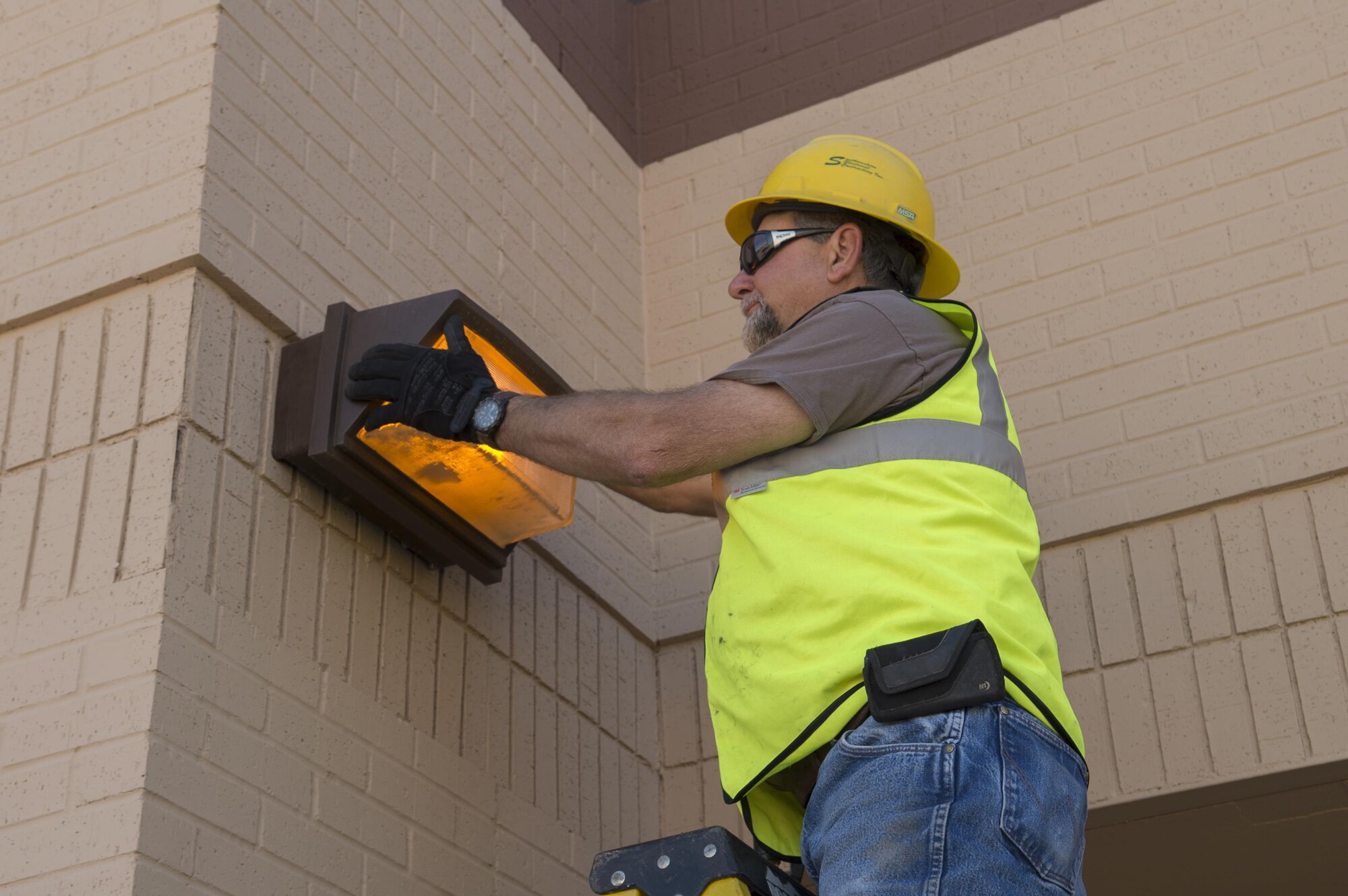 Mr. John Vullo, a contractor, changes out an old exterior light on Holloman Air Force Base, Feb. 21, 2017. The 49th Contracting Squadron finalized a contract that would change base exterior lights to light-emitting diode lights beginning Feb. 20, 2017. (U.S. Air Force photo by Tech. Sgt. Amanda Junk)