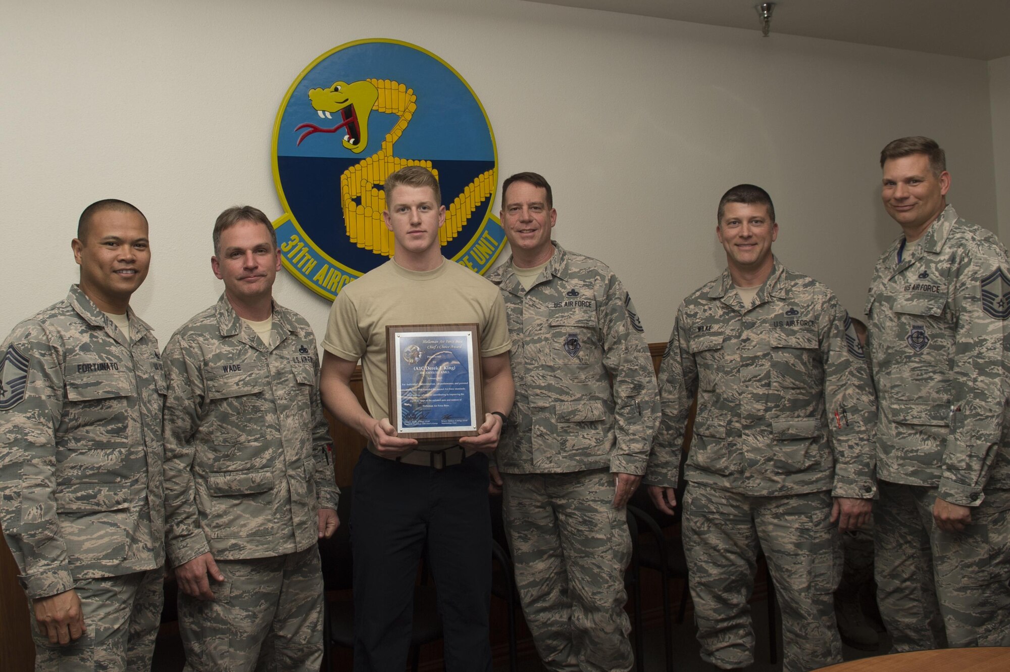 Airman 1st Class Derek J. King, a 311th Aircraft Maintenance Unit crew chief, receives the February Chief’s Choice Award from Senior Master Sgt. Brian James McRory, the 311th AMU assistant superintendent, Feb. 27, 2017, at Holloman Air Force Base, N.M. (U.S. Air Force photo by Tech. Sgt. Amanda Junk)