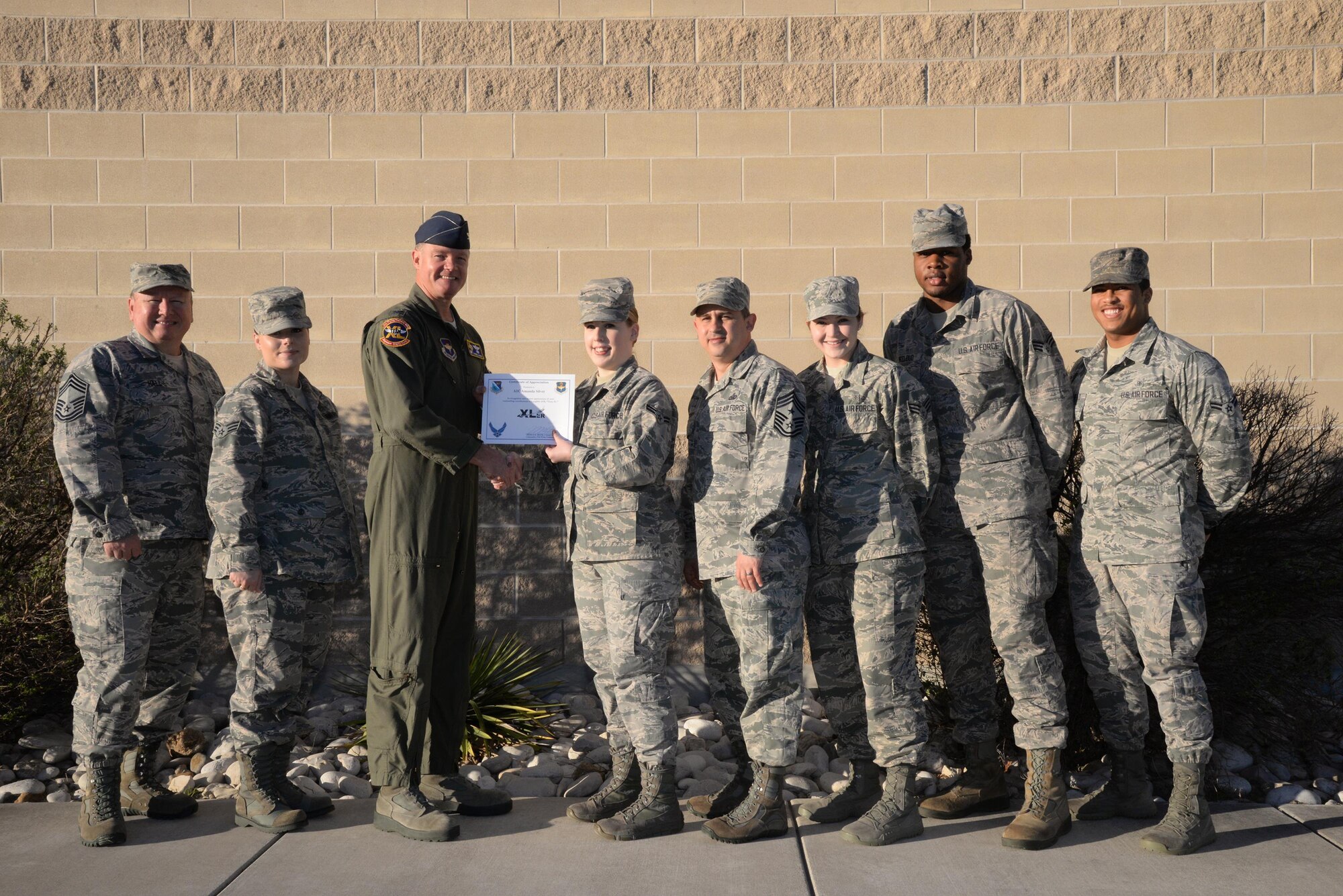 Airman 1st Class Amanda Silver, 47th Medical Group family health office clerk (center), accepts the “XLer of the Week” award from Col. Thomas Shank, 47th Flying Training Wing commander (left), and Chief Master Sgt. George Richey, 47th FTW command chief (right), on Laughlin Air Force Base, Texas, Feb. 22, 2017. The XLer is a weekly award chosen by wing leadership and is presented to those who consistently make outstanding contributions to their unit and Laughlin. (U.S. Air Force photo/Airman 1st Class Daniel Hambor)
