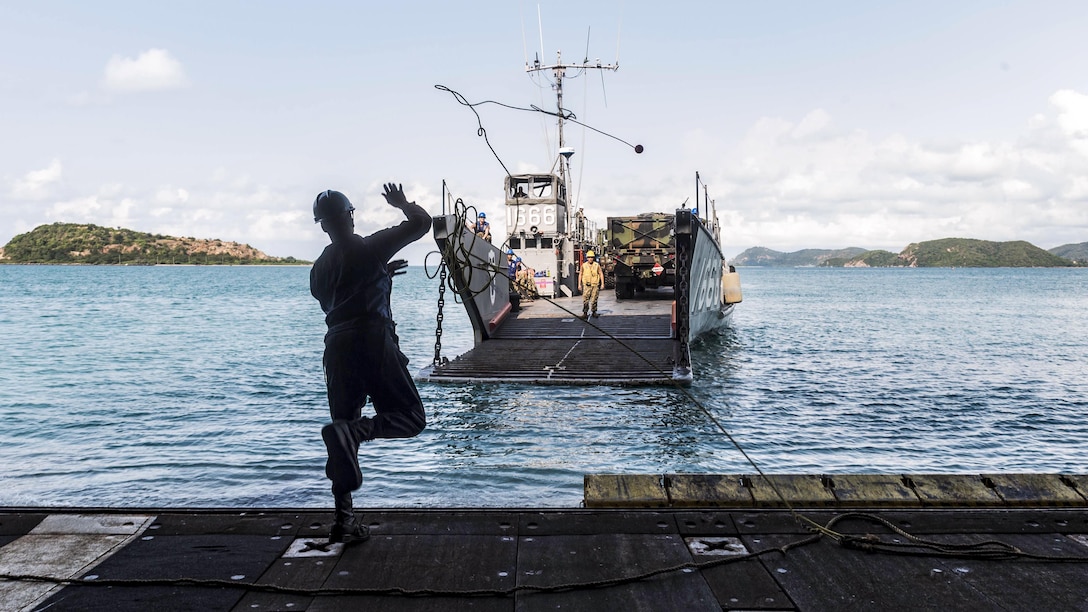 Navy Seaman Kelvin Wagner heaves a line to a landing craft as it approaches the well deck of the USS Green Bay for a stern gate marriage during Cobra Gold 2017 in Sattahip, Thailand, Feb. 24, 2017. The exercise aims to strengthen engagement in the region. Wagner is a boatswain's mate. Navy photo by Petty Officer 2nd Class Kaleb R. Staples