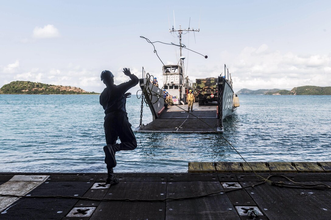 Navy Seaman Kelvin Wagner heaves a line to a landing craft as it approaches the well deck of the USS Green Bay for a stern gate marriage during Cobra Gold 2017 in Sattahip, Thailand, Feb. 24, 2017. The exercise aims to strengthen engagement in the region. Wagner is a boatswain's mate. Navy photo by Petty Officer 2nd Class Kaleb R. Staples