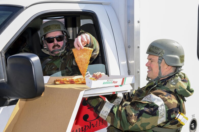 U.S. Air Force Chap. (Lt. Col.) Jeffrey Granger, 51st Fighter Wing wing chaplain, gives U.S. Air Force Tech. Sgt. Robert Lantz, 51st Aircraft Maintenance Squadron, a slice of pizza during Exercise Beverly Herd 17-1 at Osan Air Base, Republic of Korea, March 2, 2017. The wing chapel staff made morale visits to different units across the base, bringing free food and drink with them wherever they went. (U.S. Air Force photo by Staff Sgt. Victor J. Caputo)