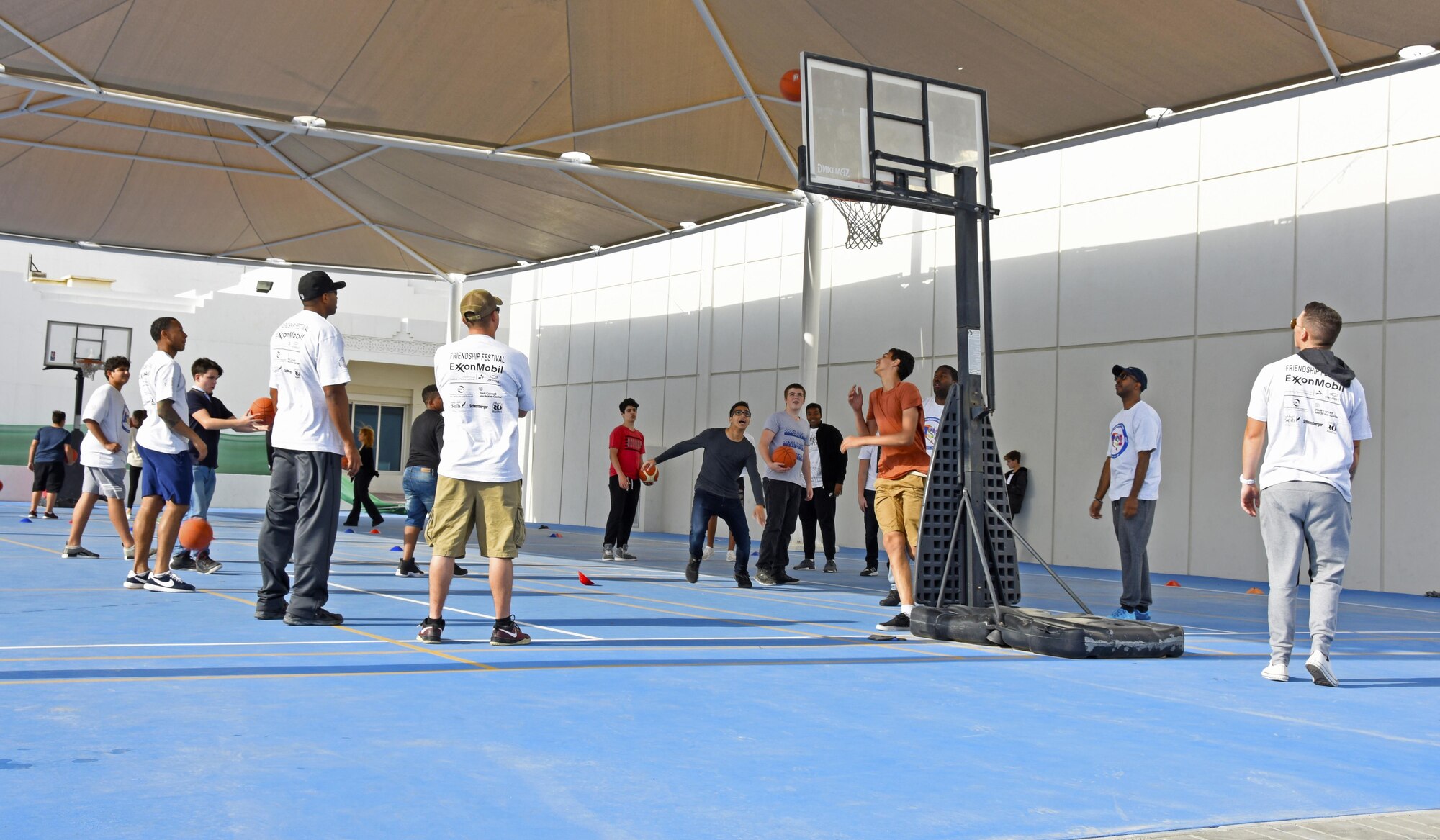 Airmen from Al Udeid Air Base, Qatar, play basketball with students during the annual American School of Doha 2017 Friendship Festival, Feb. 24, 2017. Airmen volunteered to help during the event and were encouraged to interact with ASD students, parents and staff, as well as local business owners and the many visitors who attended the festival. (U.S. Air Force photo by Senior Airman Cynthia A. Innocenti)