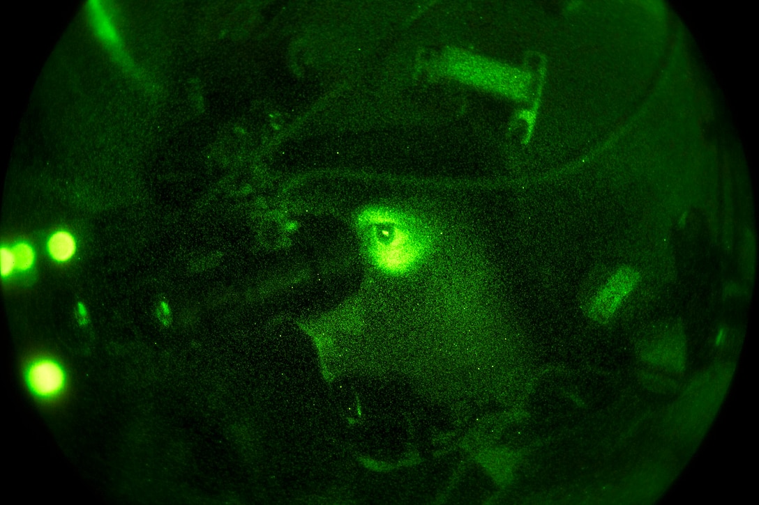 As seen through a night-vision device, an Air Force pilot uses night-vision goggles while flying a MC-130J Commmando II aircraft over Hurlburt Field, Fla., during Emerald Warrior 17, Feb. 28, 2017. Air Force photo by Staff Sgt. Corey Hook