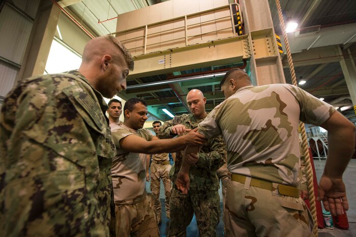 U.S. Coast Guard Petty Officer 2nd Class William Bohannon, center, and Petty Officer 3rd Class Corey Tull, maritime enforcement specialists assigned to the Maritime Engagement Team (MET), exchanges skills and tactics with members from the Iraq and Pakistan navy at Naval Support Activity Bahrain, Feb. 28th. The USCG MET is responsible for providing specialized law enforcement exercises with foreign military units around the region. 