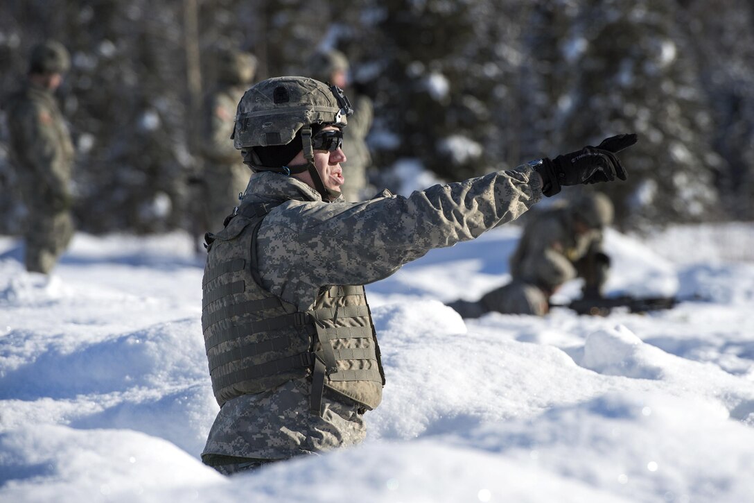 A soldier directs members of his team during machine gun live-fire training at Grezelka range, Joint Base Elmendorf-Richardson, Alaska, Feb. 28, 2017. Air Force photo by Alejandro Pena