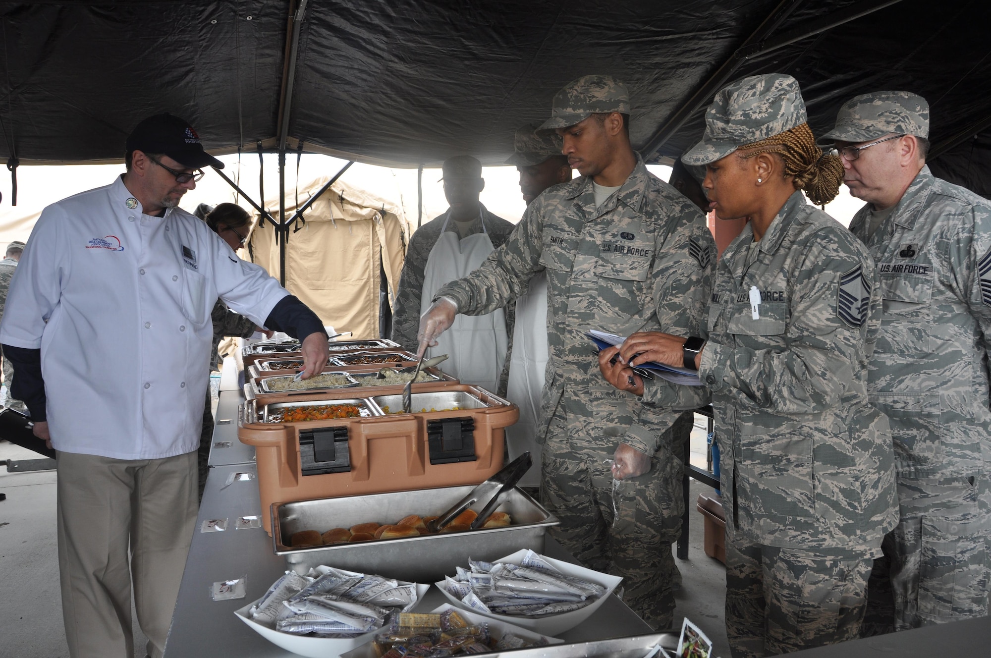 Three judges representing the Air Force Reserve Command check food temperatures and other criteria during the 908th Airlift Wing’s run competing for the John L. Hennessy Award Feb. 11 at Maxwell Air Force Base. The 908th is one of four teams vying for the award that recognizes the team who best excels in food service. (U.S. Air Force photo by Bradley J. Clark)