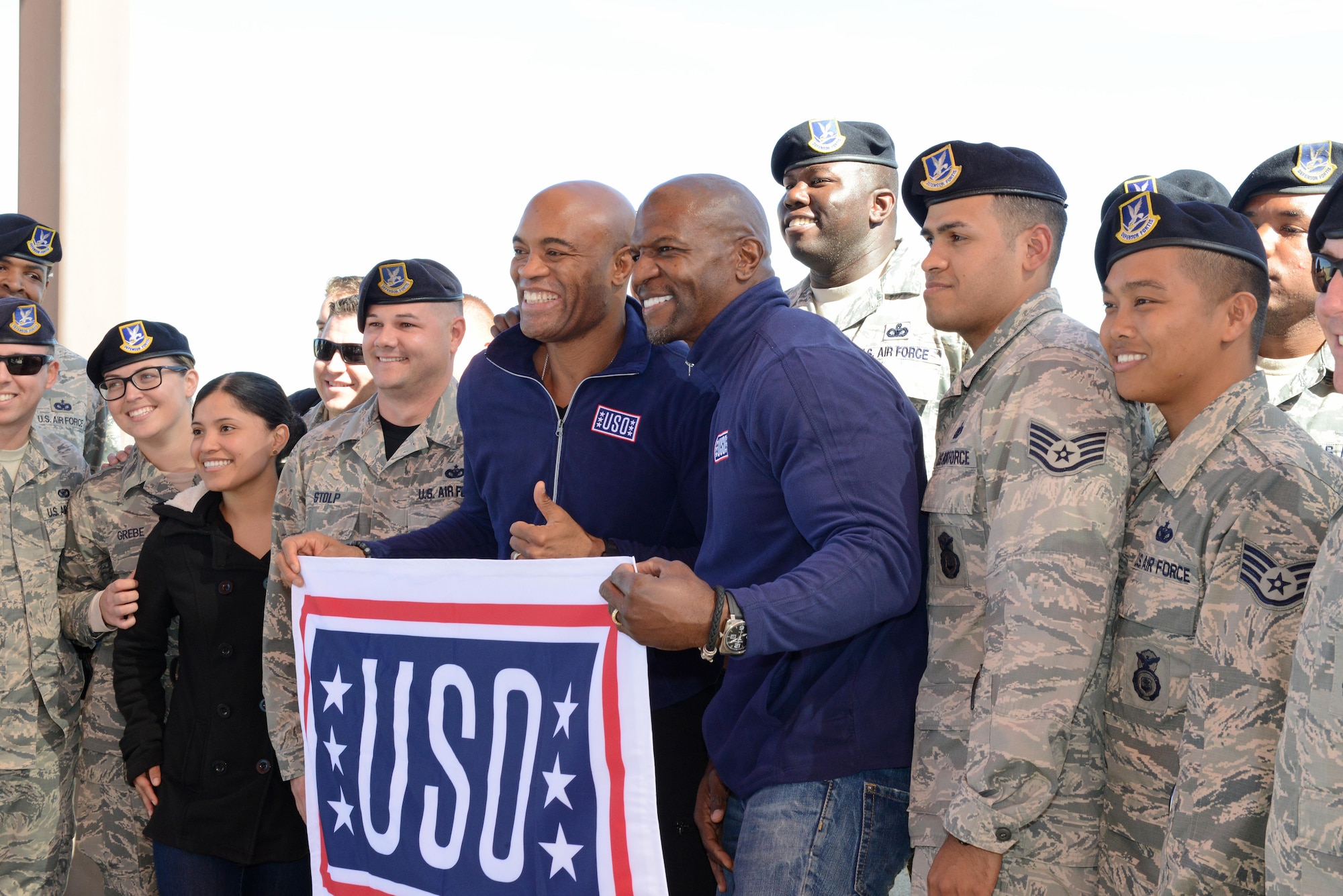Mixed martial arts fighter Anderson Silva (left) and actor Terry Crews pose for a photo with Airmen from the 412th Security Forces Squadron. The squadron put on a military working dog demonstration as part of the stars’ visit Feb. 24 to introduce the new Netflix show “Ultimate Beastmaster.” (U.S. Air Force photo by Kenji Thuloweit)