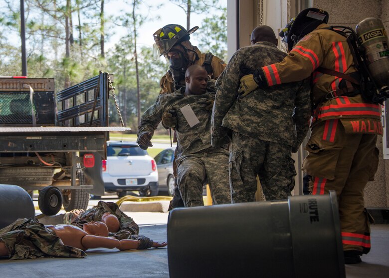 Firefighters with the 96th Civil Engineer Group, take a U.S. Army 7th Special Forces Group (A) participants to safety during an exercise Feb. 23 at Eglin Air Force Base, Fla. The simulated detonation scenario tested firefighters, security forces and medical emergency response personnel agencies among others. (U.S. Air Force photo/Ilka Cole)